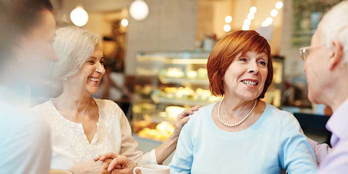 Woman at restaurant with friends wearing hearing aids