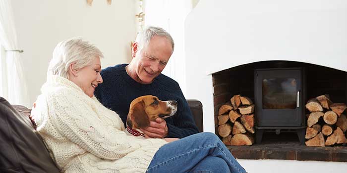 Couple petting dog at home while wearing hearing aids