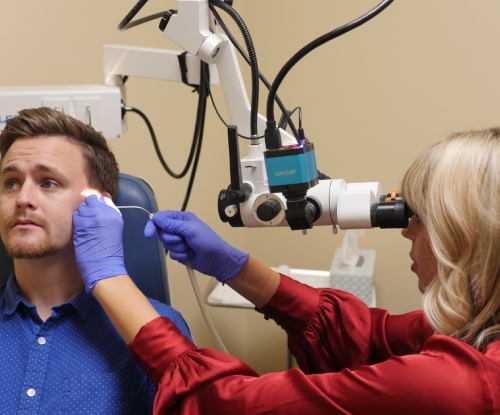 A middle-aged main receiving a hearing aid fitting from Audiologist Russ